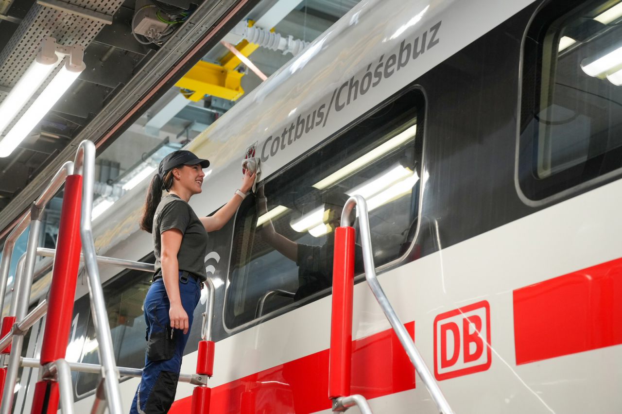 Eine Mitarbeiterin des FZI-Werkes mit Schriftzug „Cottbus / Chóśebuz“